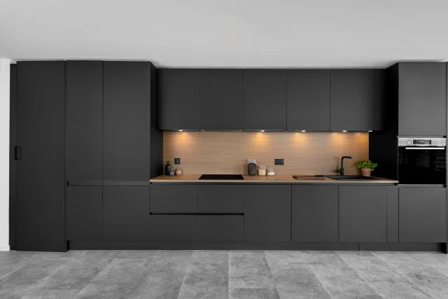 Cuisine graphite photographiée pour BP Cuisines, niche en bois et éclairage du plan de travail