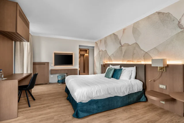 Vue d’ensemble de la chambre, du lit éclairé et des agencements en bois